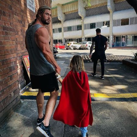 Chris Hemsworth shows his biceps while walking with his son